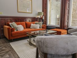 A living room with an orange sofa and coffee table at Brettargh Holt Mansion near Levens