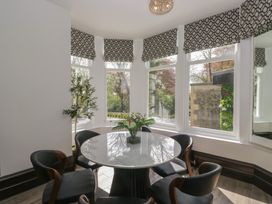 A dining room with a round table and chairs at Brettargh Holt Mansion near Levens