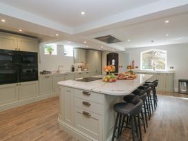 A kitchen with an island and stools at Brettargh Holt Mansion near Levens