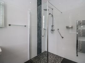 A shower with glass door and chrome fittings at Brettargh Holt Mansion near Levens