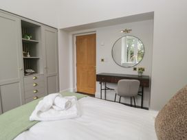 A bedroom featuring a bed, wardrobe, desk, and chair at Brettargh Holt Mansion near Levens
