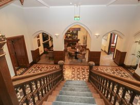 A lobby with a staircase leading to a bar area at Brettargh Holt Mansion near Levens