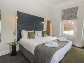 A bedroom with a bed and bedside table at Brettargh Holt Mansion near Levens