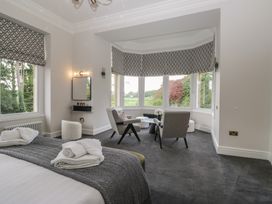 A bedroom with a bed and chairs at Brettargh Holt Mansion near Levens