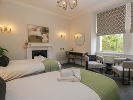 A bedroom with two beds and a writing desk at Brettargh Holt Mansion near Levens