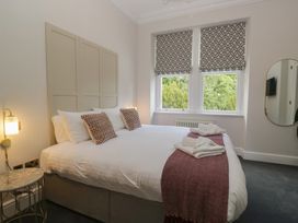 A bedroom with a bed and windows at Brettargh Holt Mansion near Levens
