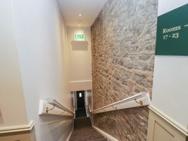 A staircase with a stone wall and exit sign at Brettargh Holt Mansion near Levens