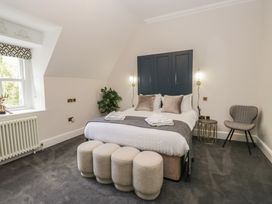A bedroom with a bed and chair at Brettargh Holt Mansion near Levens