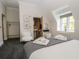 A bedroom with a bed and side chair at Brettargh Holt Mansion near Levens