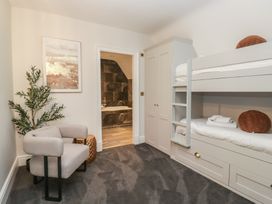 A bedroom with a bunk bed and armchair at Brettargh Holt Mansion near Levens