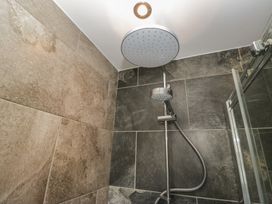 A shower area with tile walls and a shower head at Brettargh Holt Mansion near Levens