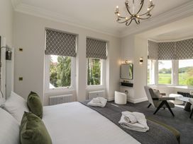 A bedroom with a bed, chair and table at Brettargh Holt Mansion near Levens