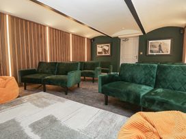 A snug with green sofas and orange bean bags at Brettargh Holt Mansion near Levens