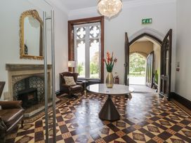 An entrance hall with a fireplace and a table at Brettargh Holt Mansion near Levens