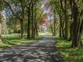 A driveway leading to a house surrounded by trees at Brettargh Holt Mansion near Levens