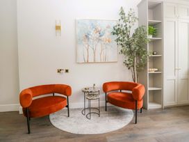 A living room with orange chairs and a small table at Brettargh Holt Mansion Sleeping 48 near Sizergh, Cumbria