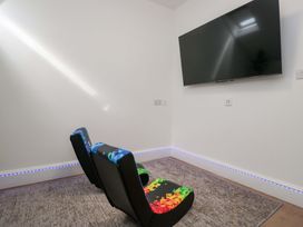 A game room with colorful armchairs and a TV at Brettargh Holt Mansion Sleeping 48 near Sizergh, Cumbria