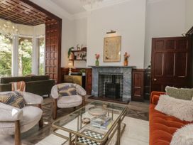A living room with a fireplace and seating at Brettargh Holt Mansion 32 near Levens
