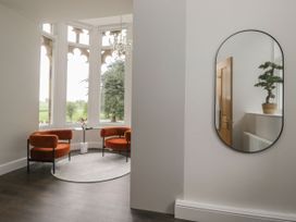 A space with orange chairs and a mirror at Brettargh Holt Mansion 32 near Levens