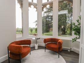 A sitting room with two orange armchairs and a side table at Brettargh Holt Mansion 32 near Levens