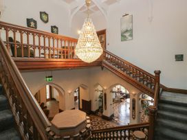 A foyer with a staircase and chandelier at Brettargh Holt Mansion 32 near Levens