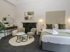 A bedroom with a bed, seating area and fireplace at Brettargh Holt Mansion 32 near Levens