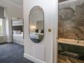 A bedroom with a bunk bed and a bathtub at Brettargh Holt Mansion 32 near Levens