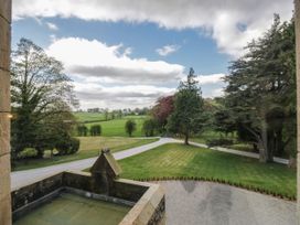 A view of a landscaped garden with trees and a driveway at Brettargh Holt Mansion 32 near Levens