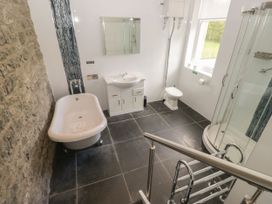 A bathroom with a bathtub, sink, toilet, and shower at Brettargh Holt Mansion 32 near Levens