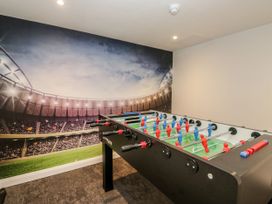 A foosball table in a game room with a sports mural at Brettargh Holt Mansion 32 near Levens