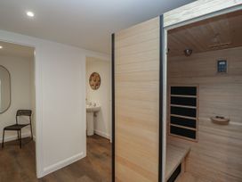 A bathroom with a sink, mirror, and sauna at Brettargh Holt Mansion 32 near Levens