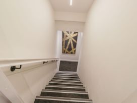 A staircase leading down with artwork on the wall at Brettargh Holt Mansion 32 near Levens
