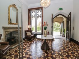 An entrance hall with a fireplace and a table at Brettargh Holt Mansion 32 near Levens