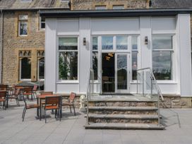 An outdoor seating area with tables and chairs at Brettargh Holt Mansion 32 near Levens