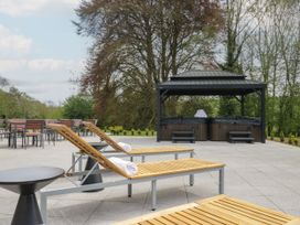 An outdoor area with lounge chairs and hot tubs at Brettargh Holt Mansion 32 near Levens