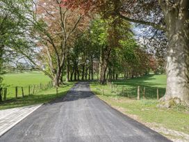 A winding path surrounded by trees and grass at Brettargh Holt Mansion 32 near Levens