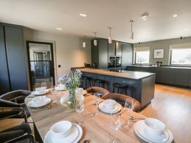 A kitchen with a dining area featuring a table set for a meal at Brynseion Uchaf near Aberystwyth