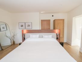 A bedroom with a bed, decorative mirror, and wardrobe at Brynseion Uchaf near Aberystwyth