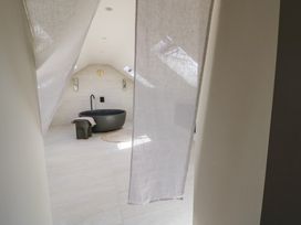 A bathroom with a bath tub and wall sconces at Brynseion Uchaf near Aberystwyth