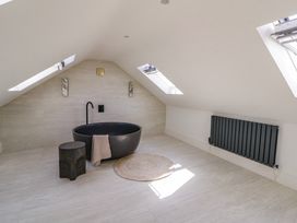 A bathroom with a bathtub and stool at Brynseion Uchaf near Aberystwyth