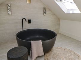 A bathroom with a black bathtub and a towel at Brynseion Uchaf near Aberystwyth