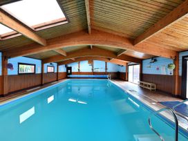 An indoor swimming pool with wooden beams at Hazelwood 3, Pinewood Retreat in Rousdon near Lyme Regis