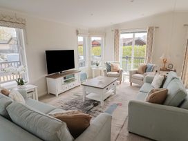 A living room with a television and seating at Hazelwood 3 in Pinewood Retreat in Rousdon near Lyme Regis