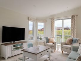 A living room with a television and seating at Hazelwood 3 in Pinewood Retreat in Rousdon near Lyme Regis