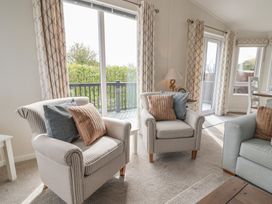 A living room with armchairs and a lamp at Hazelwood 3 in Pinewood Retreat in Rousdon near Lyme Regis