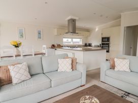 A living room with a sofa and dining area at Hazelwood 3 Pinewood Retreat in Rousdon near Lyme Regis