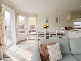 A dining area with a table and chairs at Hazelwood 3 in Pinewood Retreat in Rousdon near Lyme Regis