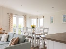 A dining room with a table and chairs at Hazelwood 3 in Pinewood Retreat in Rousdon near Lyme Regis