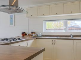 A kitchen with a gas stove and fruit bowl at Hazelwood 3 Pinewood Retreat in Rousdon near Lyme Regis