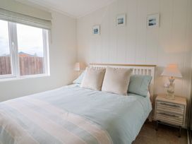 A bedroom with a bed and bedside table at Hazelwood 3 Pinewood Retreat in Rousdon near Lyme Regis